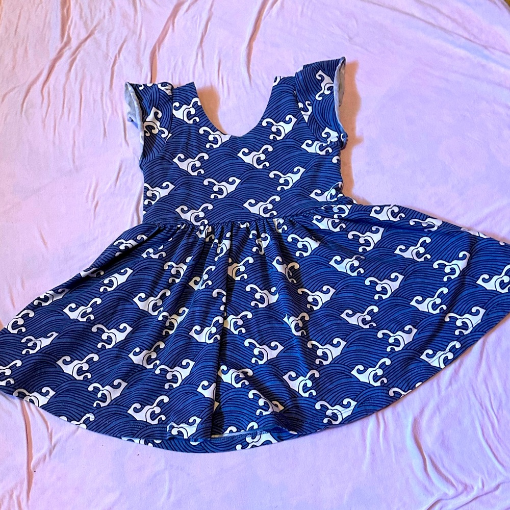 Used Monica and Andy wave dress. Short sleeved with blue printed waves.